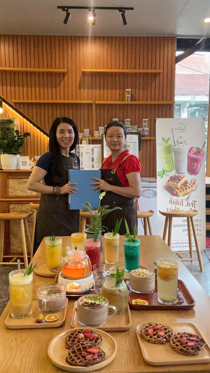 Đội ngũ học viên cùng banner Trà - Bánh - Smoothies